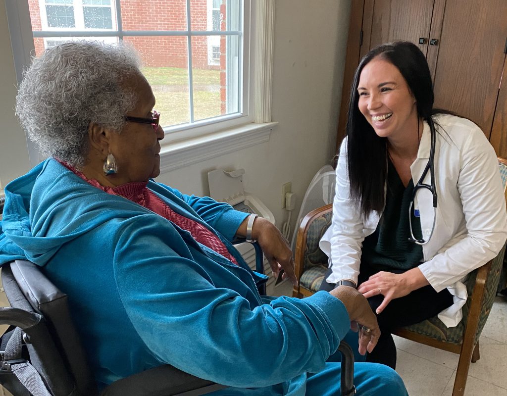 Nurse sitting laughing with patient